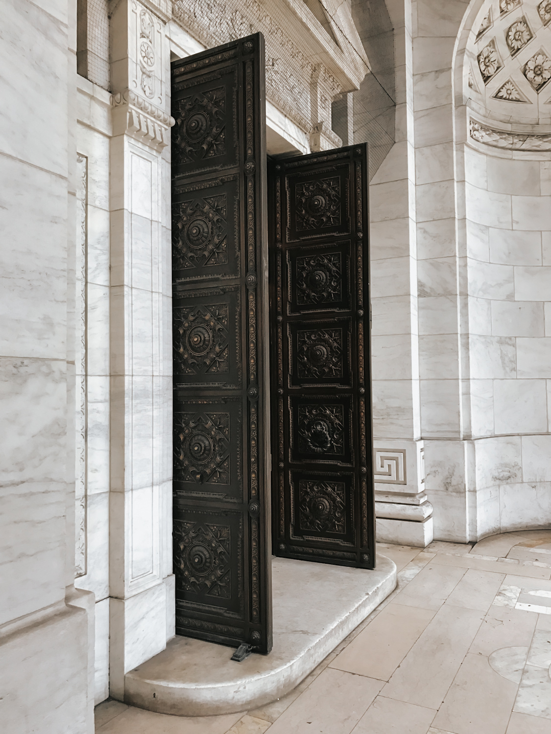 Ornate bronze doors and marble entryway inside the New York Public Library
