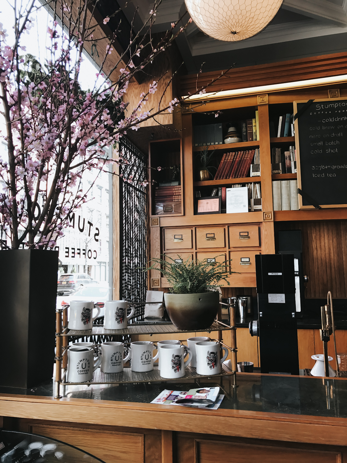 Stumptown Coffee Roasters interior with cherry blossom branches and wood shelving New York City