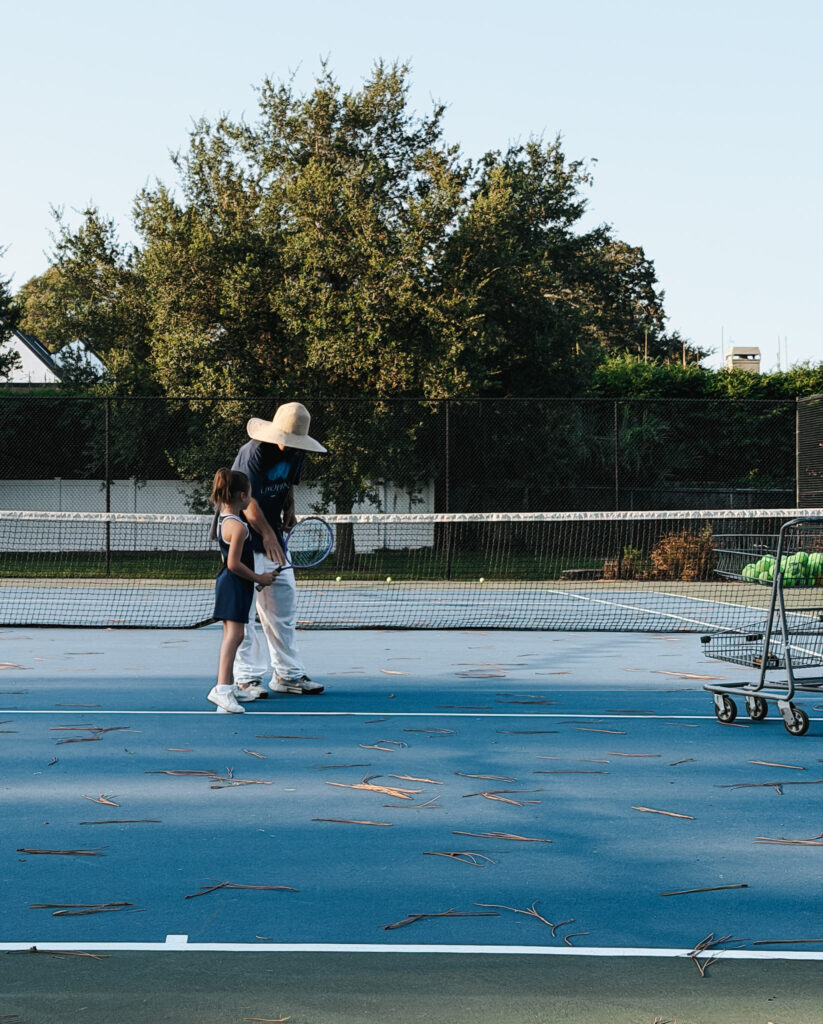 child participating in extracurricular activities for kids through beginner tennis lessons